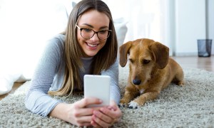 ranking of best pet apps woman with dog and phone