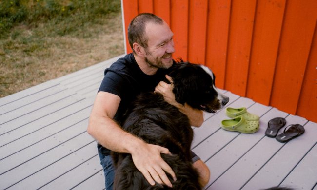 Man holds his Bernese mountain dog outside