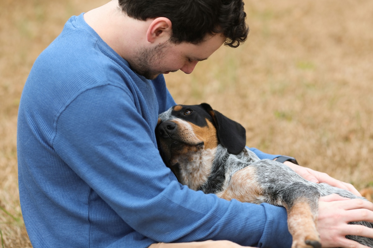 dog leaning on human in blue sweater