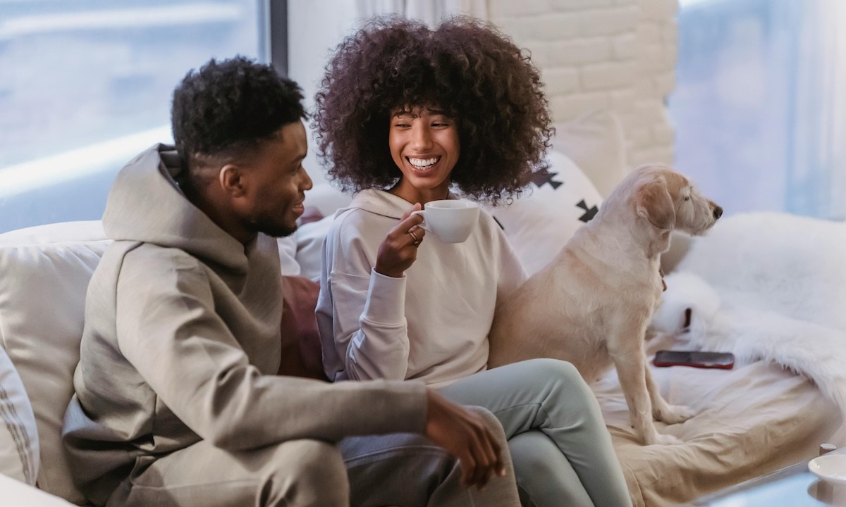 A couple on the couch with a puppy