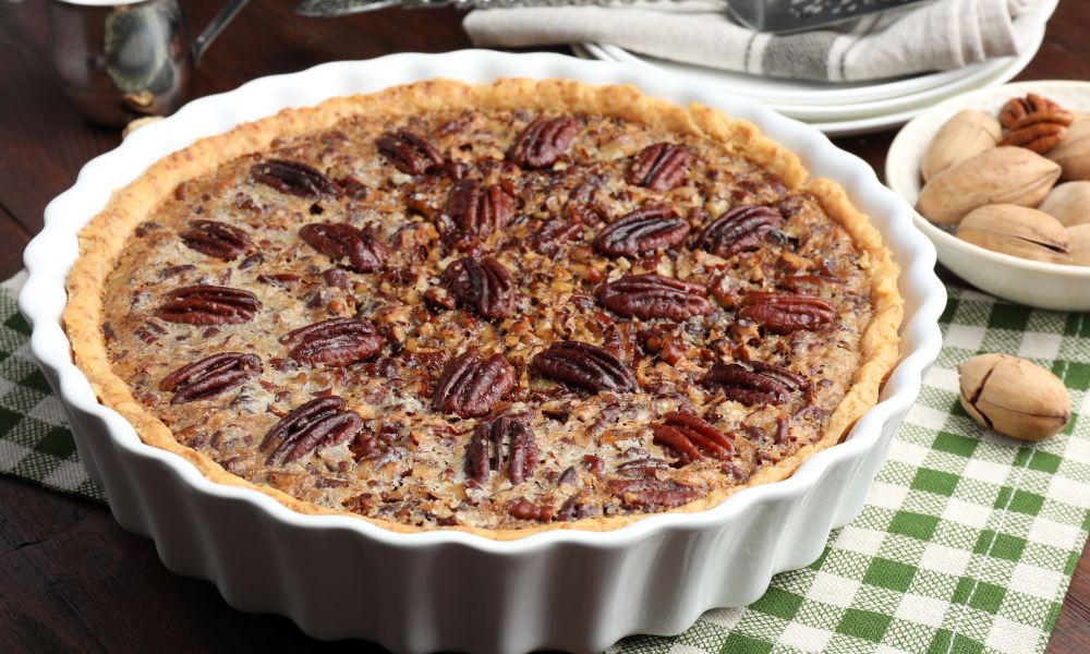 Pecan pie with pecans next to it